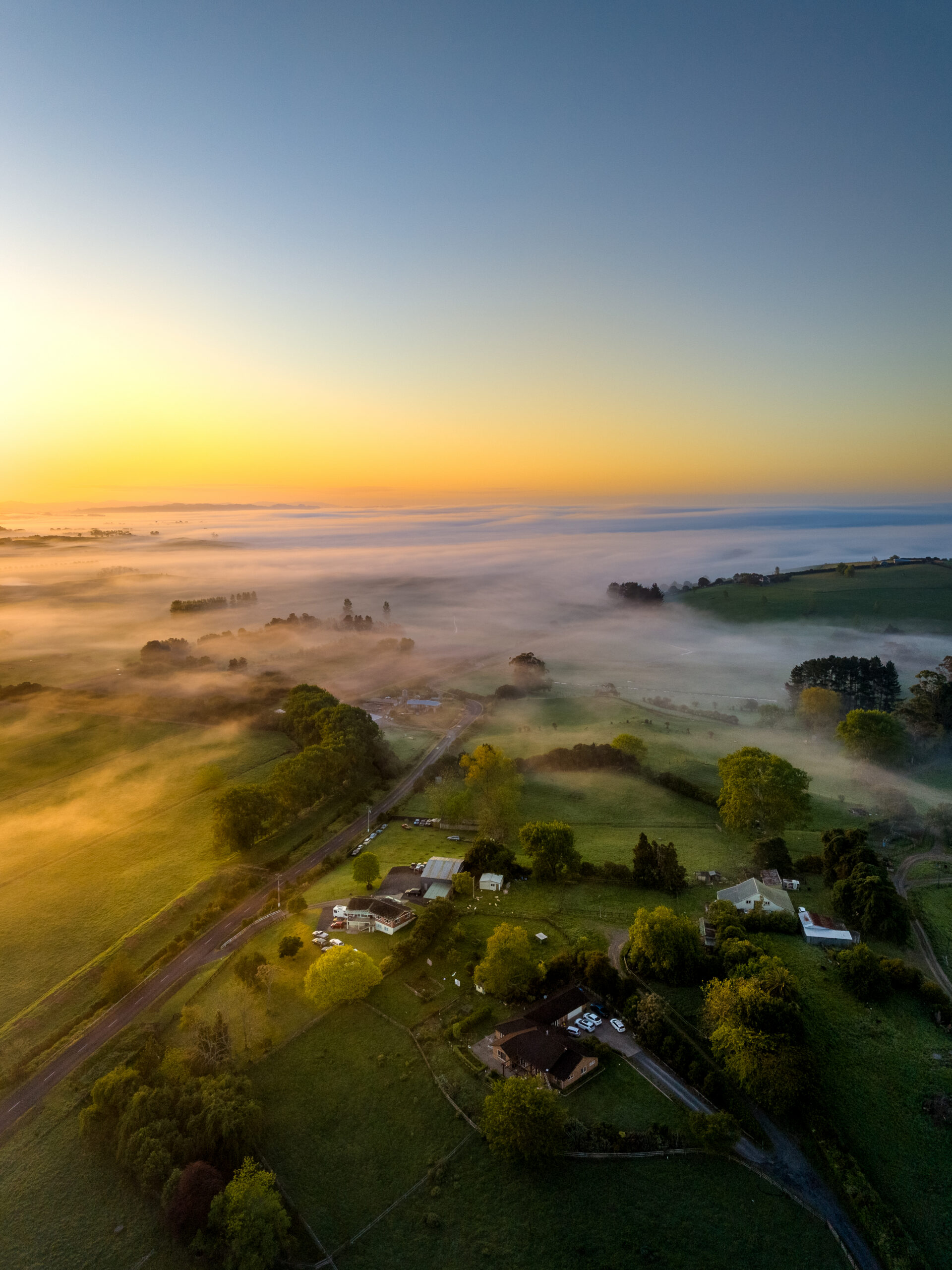 Drone shot of sunrise in the country with mist on the horizon